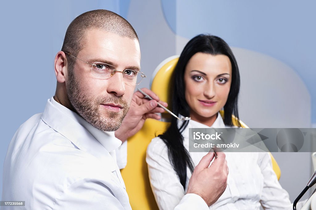 Friendly male dentist with patient Friendly male dentist with smiling patient at dental clinic Adult Stock Photo