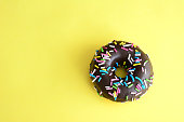 chocolate donut on yellow background copy space