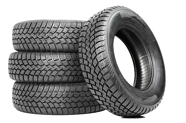 Photo of Stack of four black car tires isolated on white