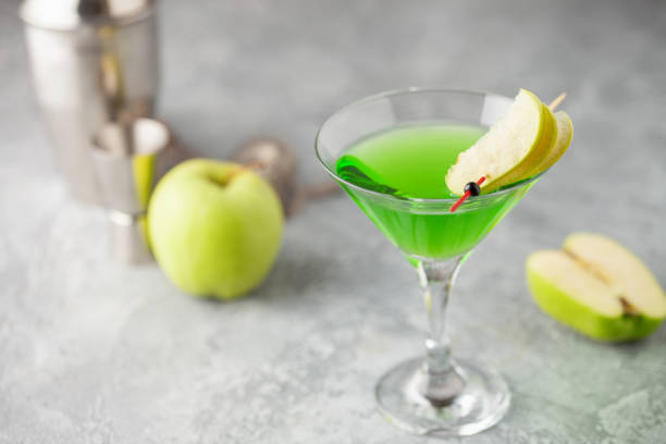 cóctel alcohólico martini de manzana o appletini agrio verde en copa de martini. herramientas de barra. - apple martini fotografías e imágenes de stock