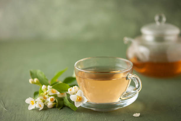 istock Composition with cup of jasmine  tea and flowers on green background 1772378761