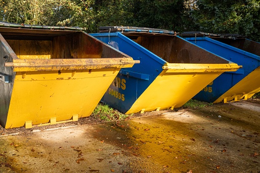 A vibrant array of blue and yellow storage containers are neatly arranged side-by-side on a sandy background