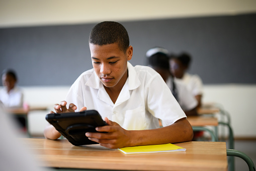 Schoolchildren using digital tablets in class to learn mathematics