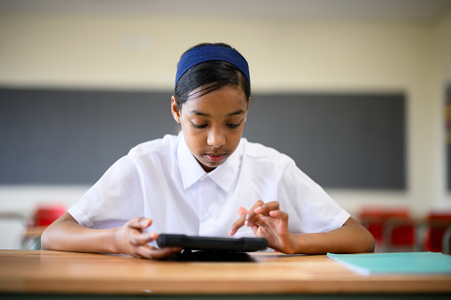 Schoolchildren using digital tablets in class to learn mathematics