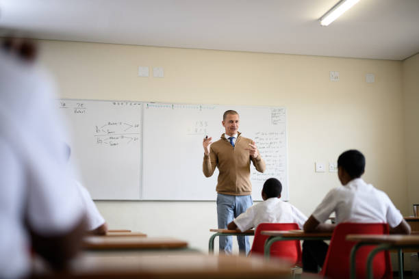 istock Teacher standing at the front of the class by whiteboard teaching mathematics 1772380686