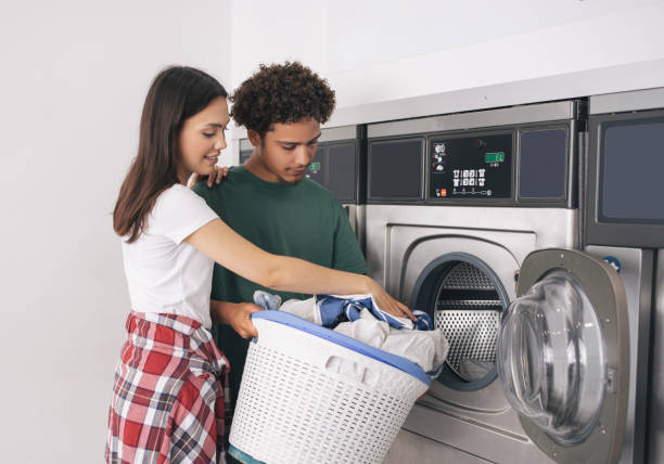 istock Young Man And Woman Folding Laundry Doing Chores At Laundrette 1772380851