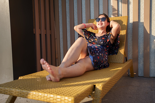 Woman basking in the sun on a deck chair