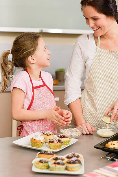 istock Daughter and mother decorating cupcakes sprinkles 177238631
