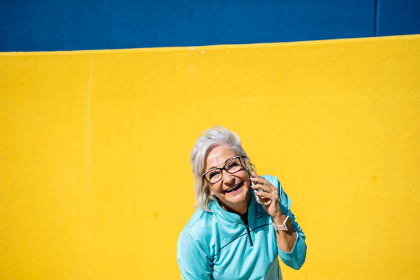 istock Mature sportive woman laughing while talking to the mobile 1772392095