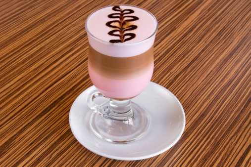 Glass of beverage made of coffee and grenadine syrup decorated with chocolate drawing