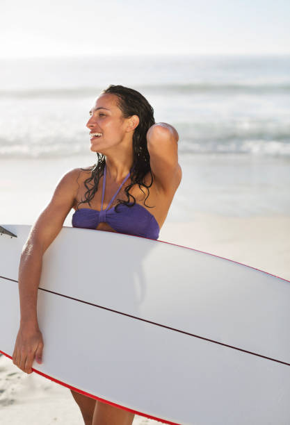 istock Smiling woman holding surfboard on beach 177240817