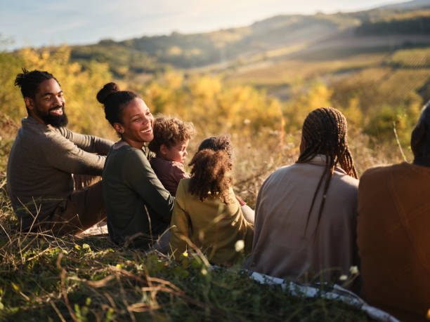 istock Relaxed black extended family talking in grass on a hill. 1772413714
