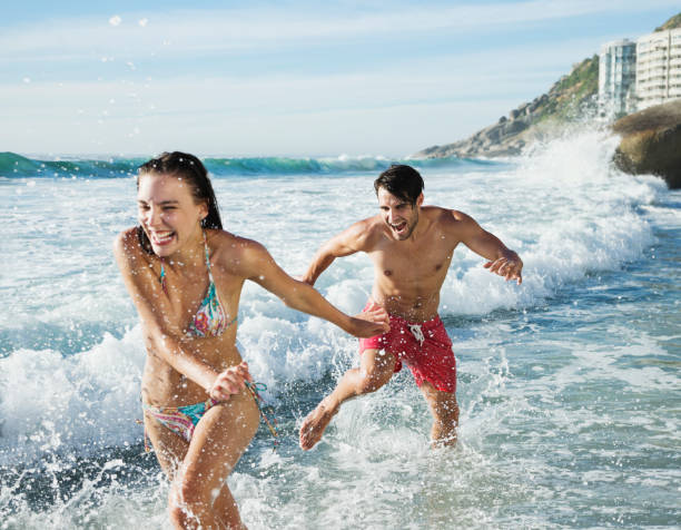 istock Playful couple splashing in ocean surf 177241507