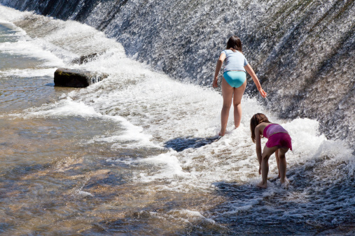 Two young girls playing and discovering a dangerous river