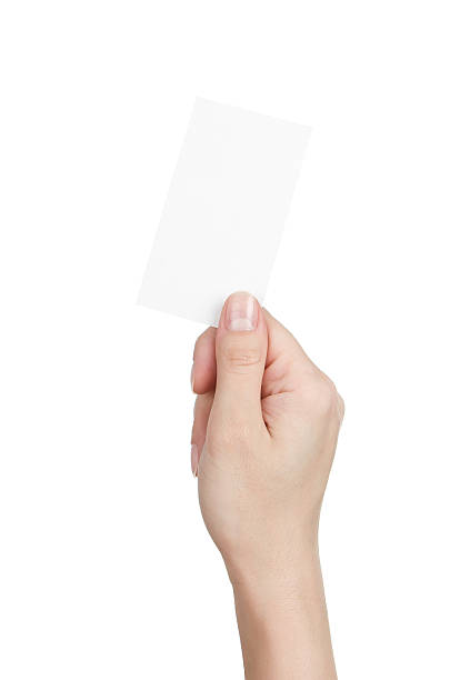 Blank business card in woman's hand Close up of female hand holding blank business card isolated on white background telephone card stock pictures, royalty-free photos & images