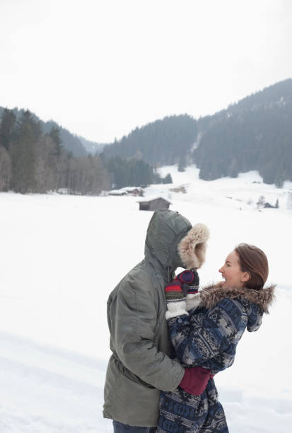istock Happy couple hugging in snowy field 177242656