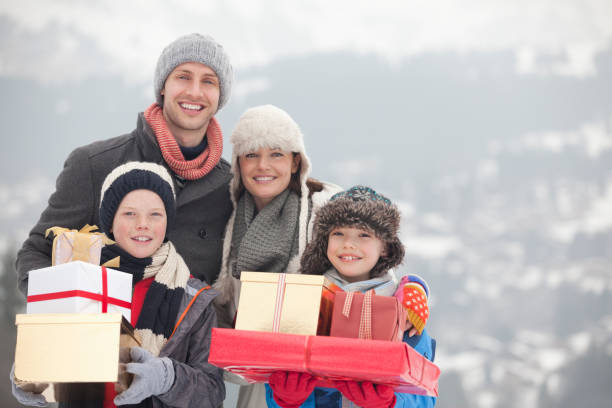 portrait of happy family with christmas gifts in snow - clothing anticipation central europe switzerland 뉴스 사진 이미지