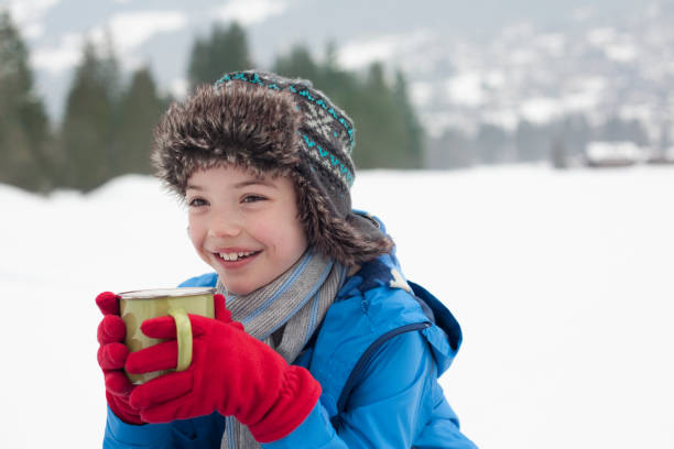 istock Happy boy drinking hot chocolate in snowy field 177243015