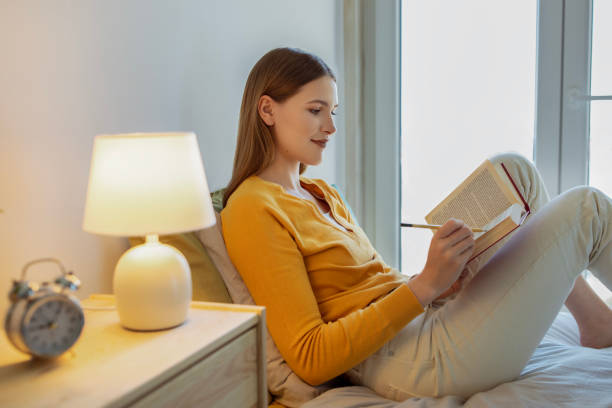 istock Student Girl Reads Paperback Book And Taking Notes In Bedroom 1772430428