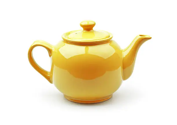 Photo of A shiny yellow teapot on a white background