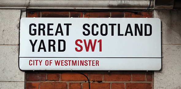 Classic London street sign again red brick wall. Central London on desirable street