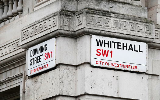 London, UK - March 15, 2023: Downing Street and Whitehall street sign on a government building in the City of Westminster, London, UK.