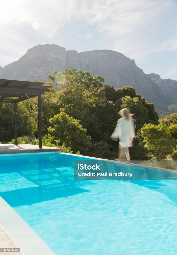 Woman walking along swimming pool  Blurred Motion Stock Photo