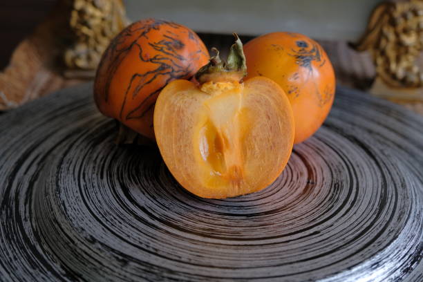 istock persimmon fruit. fresh persimmon fruit cut in half. Kaki plum fruit, Japanese persimmon, Diospyros kaki Lycopersicum 1772443228
