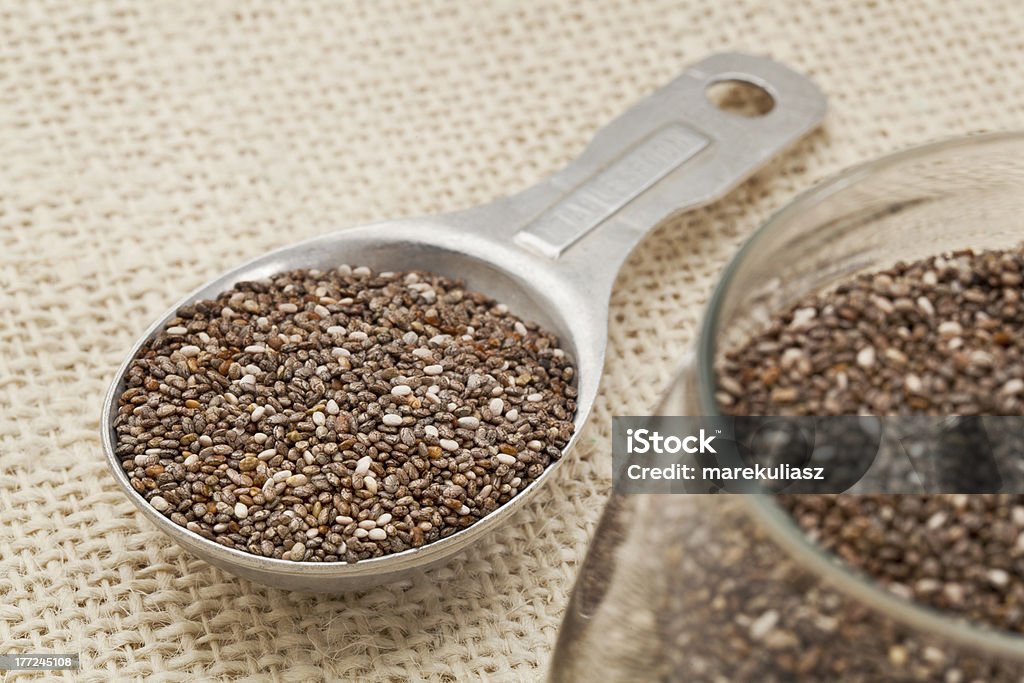 tablespoon of chia seeds "chia seeds in glass jar and on measuring aluminum tablespoon against burlap background, focus on the spoon" Alternative Medicine Stock Photo