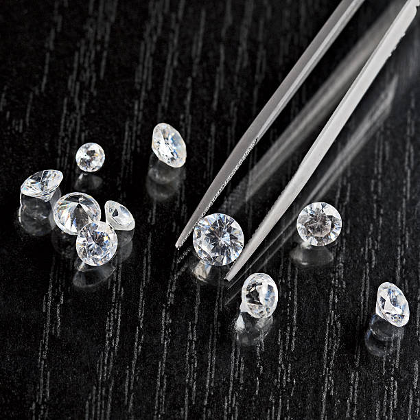 istock loose diamond on black surface with tweezers 177245124