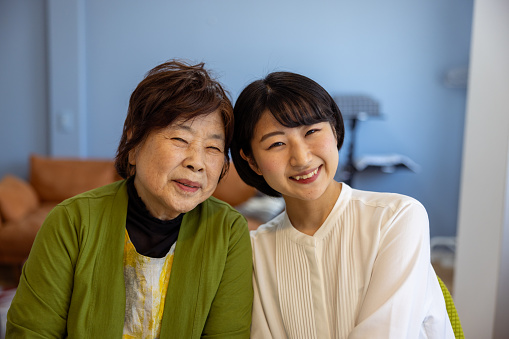 Family portrait of grandmother and granddaughter at home