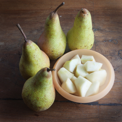 chopped and whole pears on a wooden table