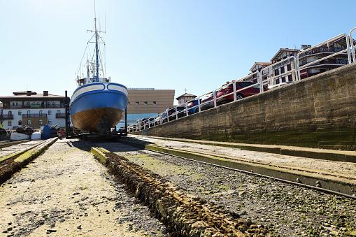 Hondarribia, Gipuzkoa, Spain- August 13, 2023:Blue fishing ship in the slipway of the port of Hondarribia