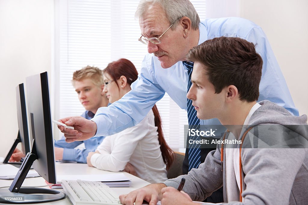 Computer training Group of students  with a teacher in computer classroom Adolescence Stock Photo