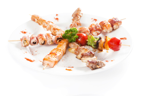 Japanese Cuisine - meat pieces Wrapped in Bacon and grilled vegetables over white background.