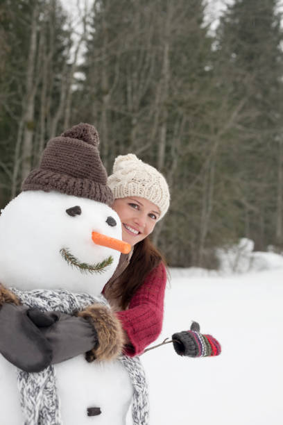 istock Happy woman hugging snowman in woods 177246326
