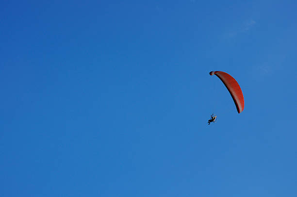 Paramotor flying on blue sky Paramotor flying on blue sky para ascending stock pictures, royalty-free photos & images