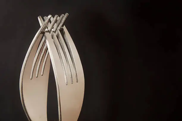 Two forks with black background. Selective focus.