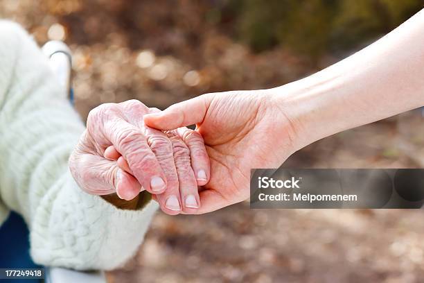 Senior Lady Holding Hands With Young Caretaker Stock Photo - Download Image Now - Holding Hands, Senior Adult, A Helping Hand