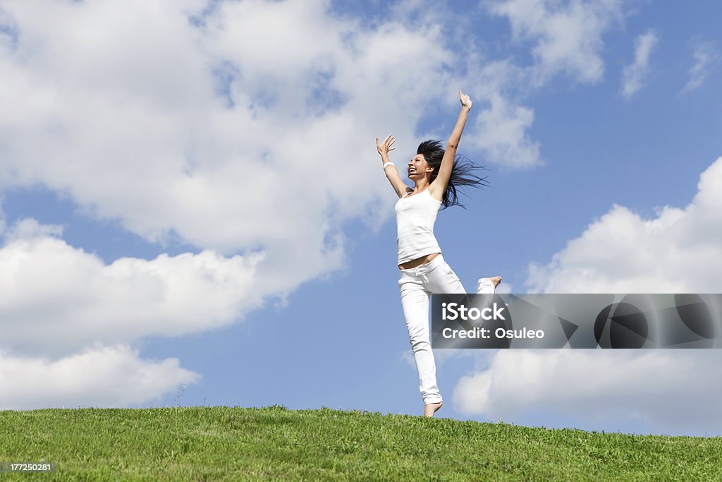 Bela jovem pulando na grama verde - Foto de stock de Adulto royalty-free