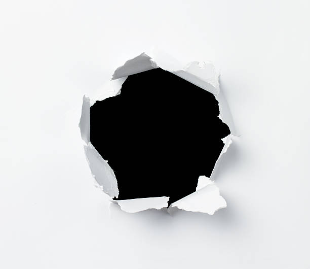 Hole Hole in the paper sheet over black background peeking photos stock pictures, royalty-free photos & images