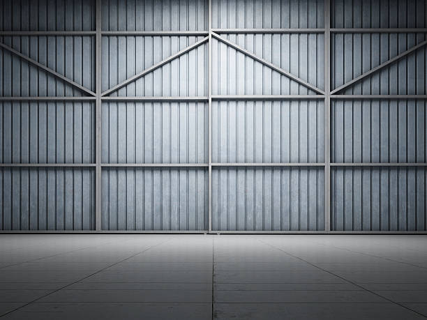 Large warehouse door illuminate Large warehouse door illuminate spot light airplane hangar stock pictures, royalty-free photos & images