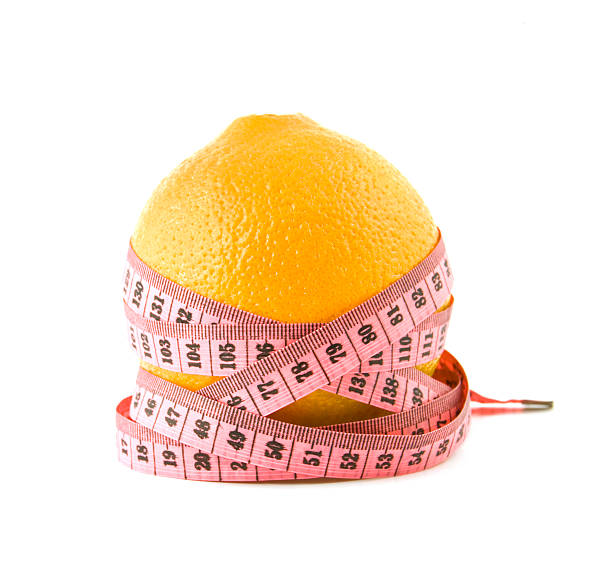orange is tied around by a centimetre  white background orange is tied around by a centimetre on a white background centimetre stock pictures, royalty-free photos & images