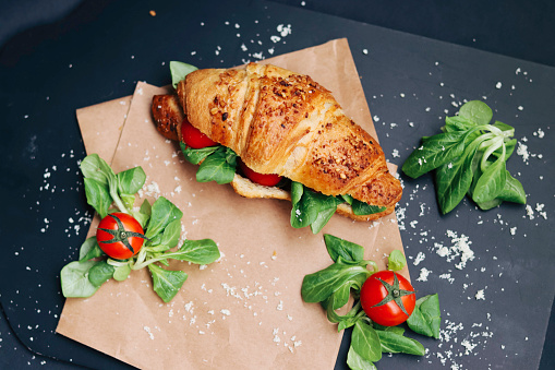 Croissant with cherry and cheese and plants.