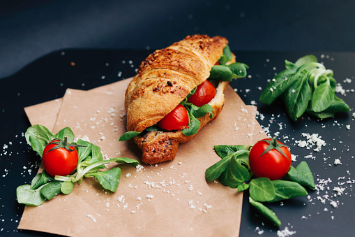 Croissant with cherry and cheese and plants.