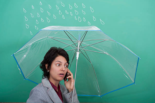 Young woman standing in front of blackboard holding an umbrella stock photo