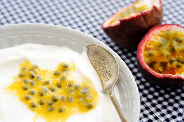Plain yoghurt with granadilla pulp with fresh granadilla in the background