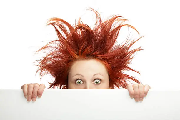 Photo of Ginger woman having bad hair day holding a blank board