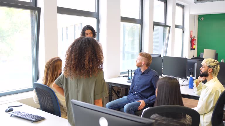 Man leading a meeting with young people in a coworking