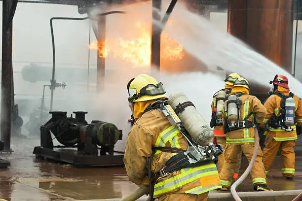 Selective focus is on the firefighter in the foreground.